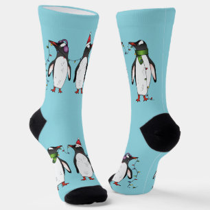 Drie vrolijke kerstpinguïns op lichtblauw sokken