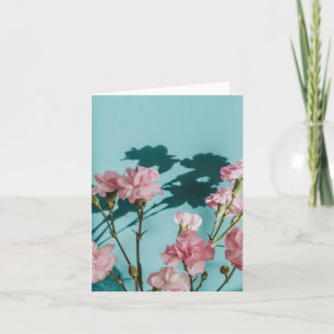 Dromerige roze anjerbloemen op blauwe achtergrond kaart