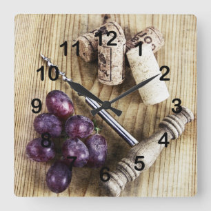 Druiven, kurken van wijnflessen en schroefschroeve vierkante klok