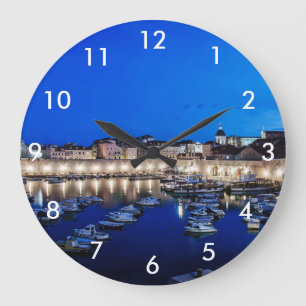 Dubrovnik haven en muren verlicht 's nachts grote klok