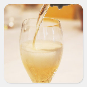 Een champagneglas wordt gevuld met Gosset Vierkante Sticker