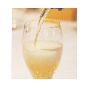 Een champagneglasfluit die wordt gevuld met Gosset Notitieblok