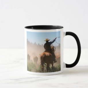 Een cowboy die aan het werk is met de kudde op een mok