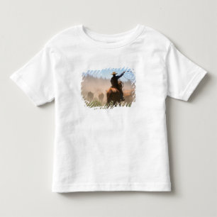 Een cowboy die buiten werkt met de kudde op een ve kinder shirts