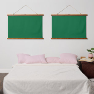 Een diepgroene achtergrond contrasteert met een kn hangend wandkleed