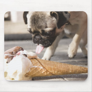 Een hond die een ijsje uit een bedekking eet muismat