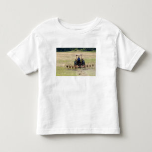 Een jonge jongen die een tractor bestuurt om te oo kinder shirts