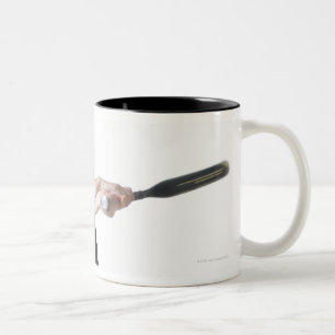 een jonge kaukasische vrouw draagt een tweekleurige koffiemok