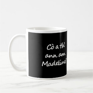 Eén kant van de mok zegt Cò a th' ann am Madeline?
