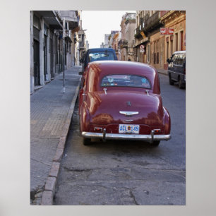 Een klassieke rode Peugeot-auto geparkeerd op stra Poster