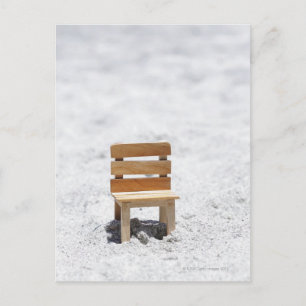 Een kleine stoel op het zandige strand briefkaart