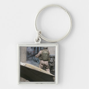 Een militair politieagent gebruikt een breekt rond sleutelhanger