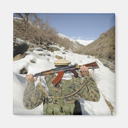 Een Mujahadeen Guard loopt met een Amerikaans mili Magneet (Voorkant)