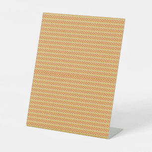 Een oranje en gele achtergrond met kleine stippen reclamebord met voetstuk