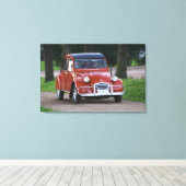 Een oude rode 2CV-wagen met een lachende vrouw Canvas Afdruk (Insitu (Houten vloer))