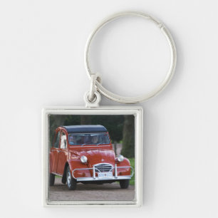 Een oude rode Citroen 2CV auto met een lachende vr Sleutelhanger