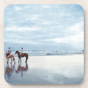 Een paar rijpaarden op het strand van Parkiri in N Onderzetter