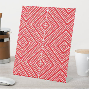 Een rode en witte achtergrond met een diamantpatro reclamebord met voetstuk