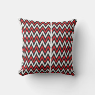 Een rood en zwart zigzagpatroon op een witte achte kussen