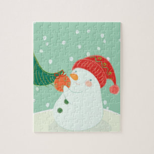 Een sneeuwman die een versiering aan een boom hang legpuzzel