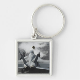 Een stuurhutregisseur signaleert een F/A-18F Sleutelhanger