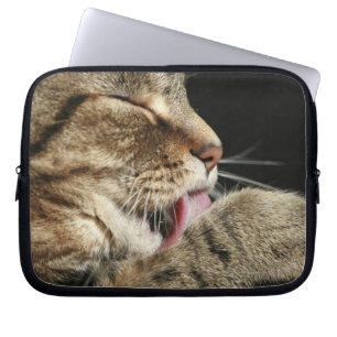 Een tabby kat die zijn poot likt. laptop sleeve