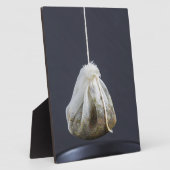 Een theezakje zit in een beker. fotoplaat (Zijkant)