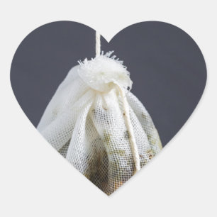Een theezakje zit in een beker. hart sticker