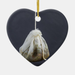 Een theezakje zit in een beker. keramisch ornament