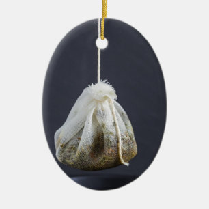 Een theezakje zit in een beker. keramisch ornament