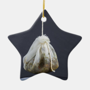 Een theezakje zit in een beker. keramisch ornament