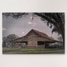 Een verweerde houten schuur omgeven door weelderig