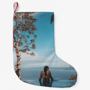 Een vrouw met een zwarte bikini kraan zwemt op het kleine kerstsok