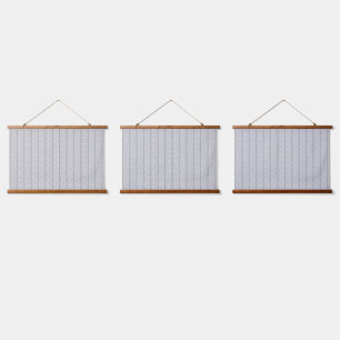 Een wit en grijs geometrisch patroon vult het afbe hangend wandkleed