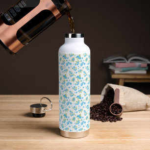 Een witte achtergrond met blauwe bloemen en groene waterfles