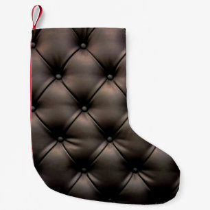 Een zwarte lederen kussenachtergrond, vanaf een au kleine kerstsok