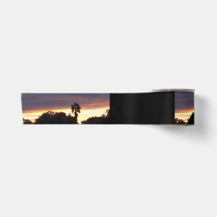 En Satin Ruban avec palmier et nuages sombres au coucher du
