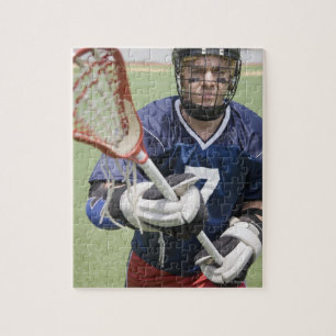 Ernstige lacrosse speler die kruis vasthoudt legpuzzel