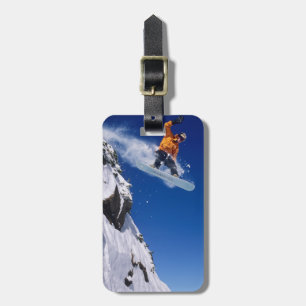 Étiquette À Bagage Homme sur un snowboard sautant d'une corniche à