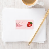Étiquette Fruit de fraise rouge sur fond rose avec texte per (En situation)