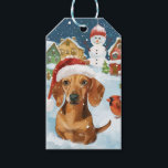 Étiquettes-cadeau Dachshund Winter Wonderland Christmas Joy<br><div class="desc">Ce design festif reflète l'esprit joyeux de la période des fêtes, avec un adorable petit portant un chapeau de Père Noël. Le chien est niché dans un pays des merveilles hivernales, avec un bonhomme de neige, un sapin de Noël décoré et des cadeaux joliment emballés. Les flocons de neige tombent...</div>