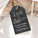 Étiquettes-cadeau Script rustique Chalkboard Mariage L'amour est dou<br><div class="desc">Charming chalkboard cardstock étiquettes de faveur fonctionnalité "L'amour est doux" avec un monogramme de mariage personnalisé en polices de style manuscrit avec un accent de conception de coeur et de défilement qui ont un aspect craie blanche. Arrière - plan a un aspect rustique en carton noir texturé.</div>