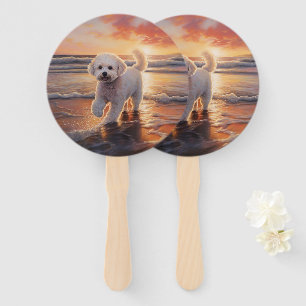 Éventail Bichon Frise Sandy Paws sur la plage au coucher du