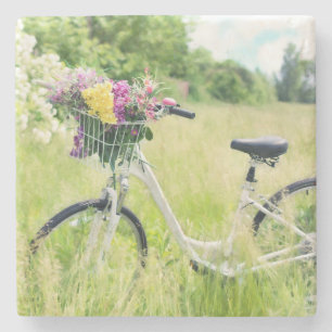Fiets met bloemenmand in de weide stenen onderzetter