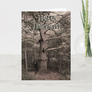 Fille derrière la carte d'halloween de l'arbre