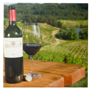 Fles van rode wijn en glas op tafel tegeltje