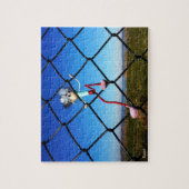 Fubby poppetje dat in het hek omhoog klimt. legpuzzel (Verticaal)