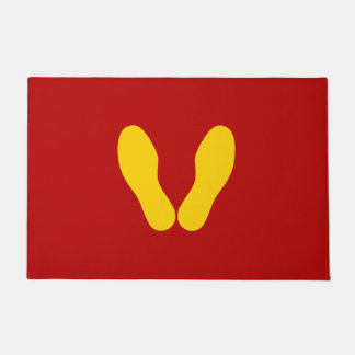 GEEL VOETPRINES OP RODE DEURMAT