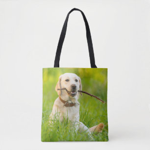 Gele labrador bespeelt zich op een stok draagtas