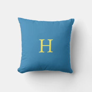 Gele monogram op turkooisblauw kussen